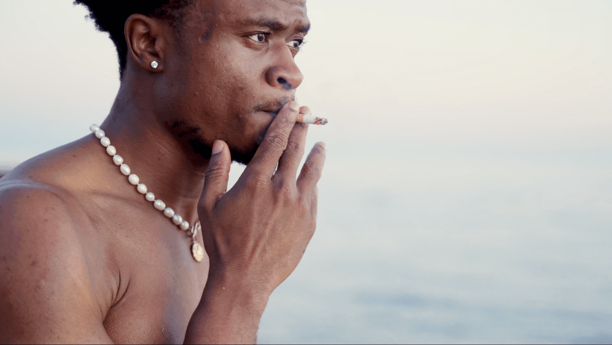 Cinematic Video & Photography Services - dymon creative – PFlow smoking on a beach.